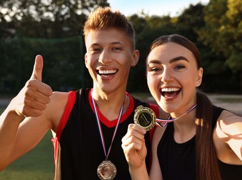 Happy winners with medals taking selfie at stadium