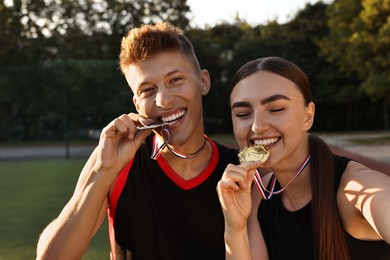 Photo of Happy winners with medals taking selfie at stadium