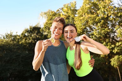 Photo of Happy winners with medals outdoors on sunny day