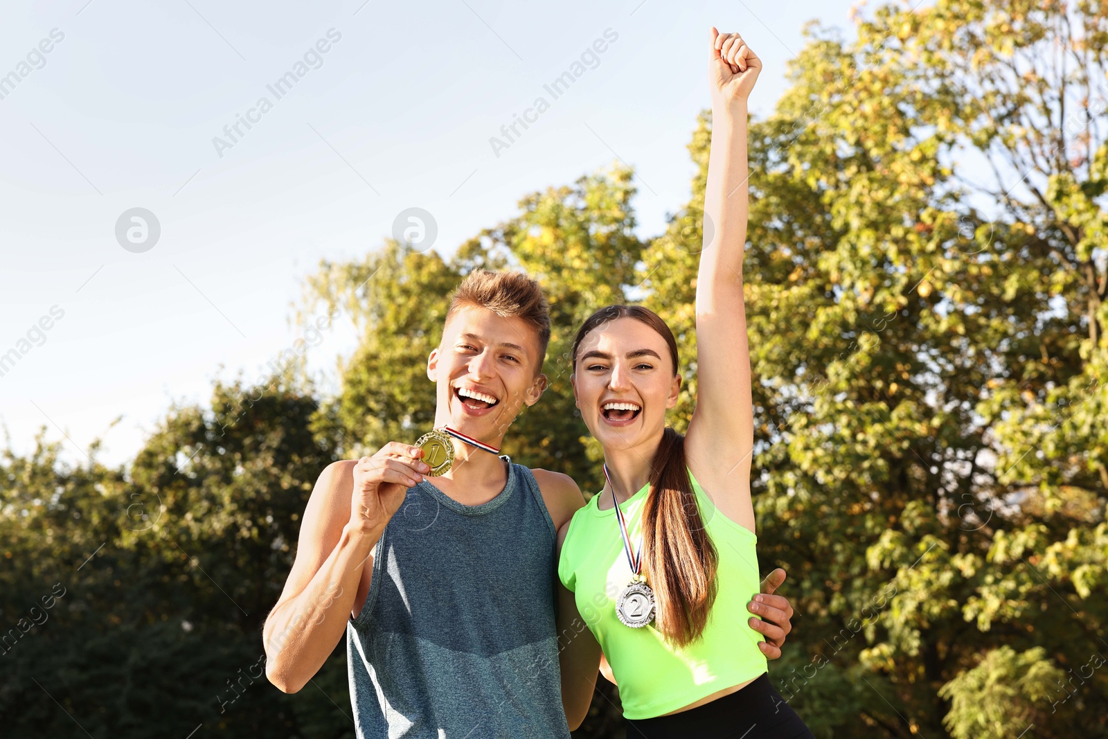 Photo of Happy winners with medals outdoors on sunny day