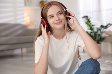 Photo of Portrait of teenage girl in headphones at home