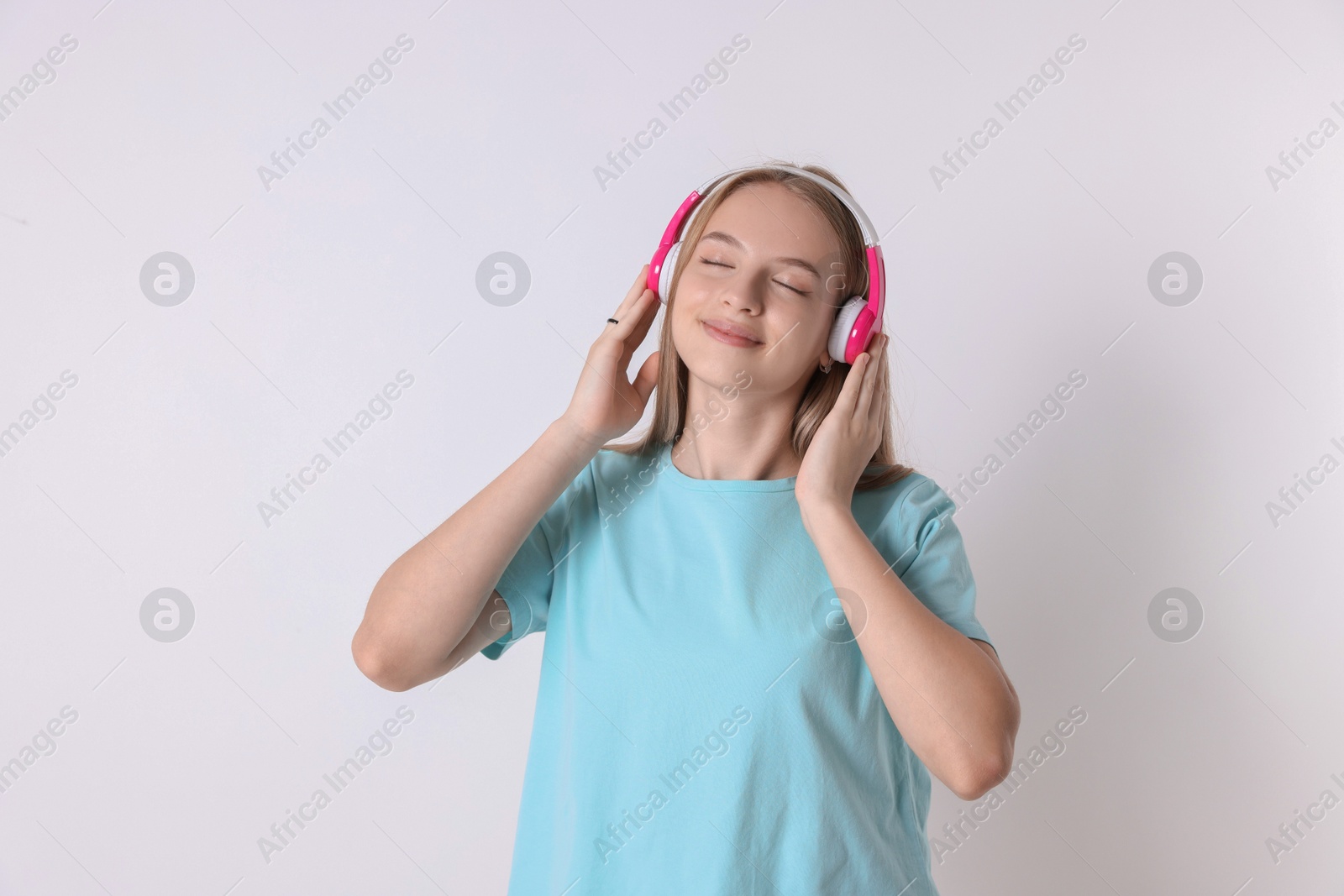 Photo of Portrait of teenage girl in headphones on white background