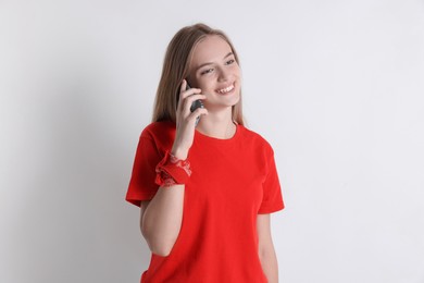 Teenage girl talking on smartphone against white background