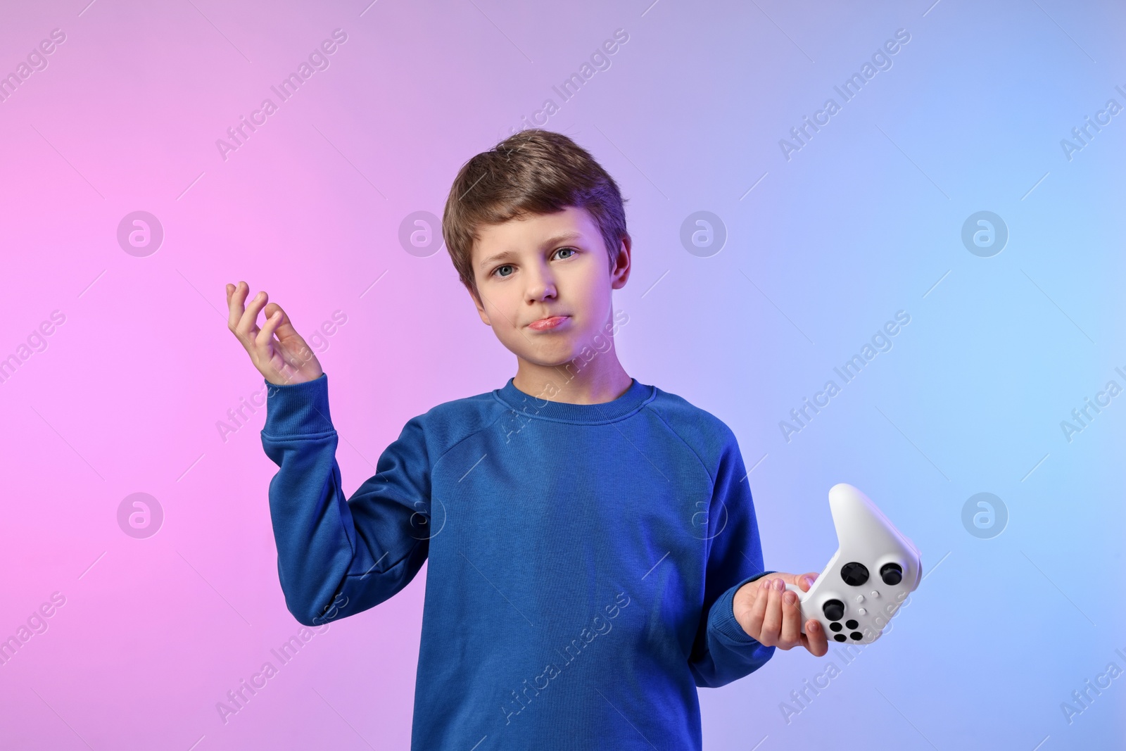 Photo of Cute little boy with controller on color background