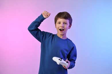 Photo of Happy little boy with controller on color background