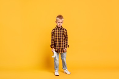 Photo of Little boy with controller on orange background