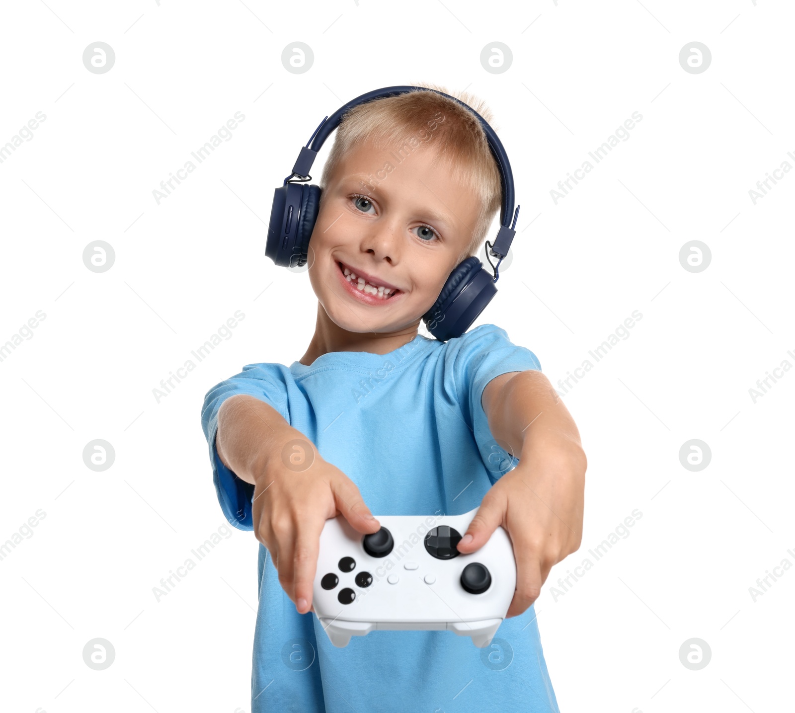 Photo of Happy little boy in headphones playing video game with controller on white background