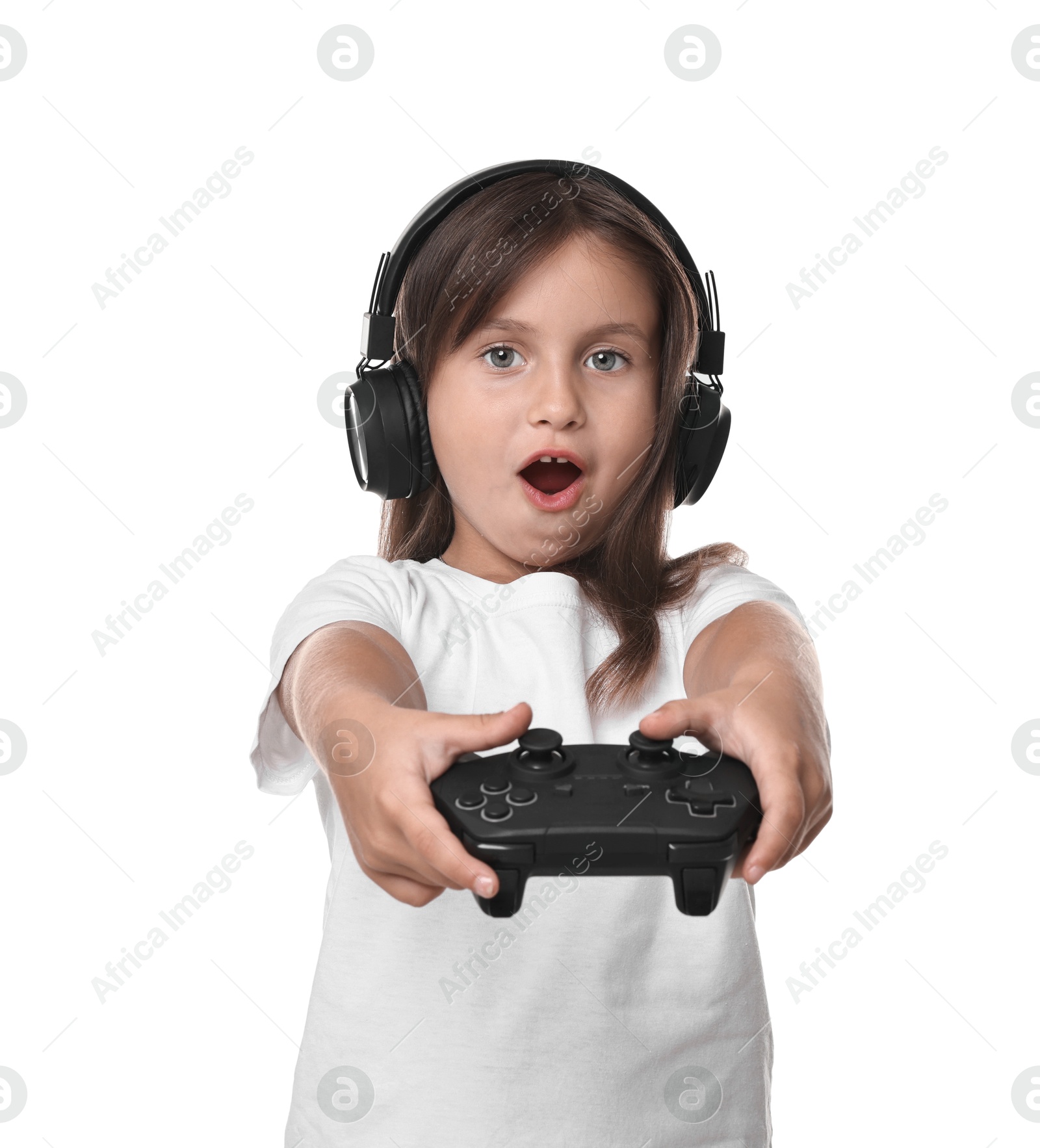 Photo of Cute little girl in headphones playing video game with controller on white background