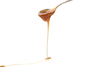 Photo of Tasty caramel sauce dripping from spoon on white background, closeup