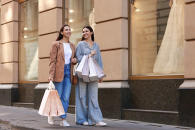 Photo of Happy women with many shopping bags outdoors