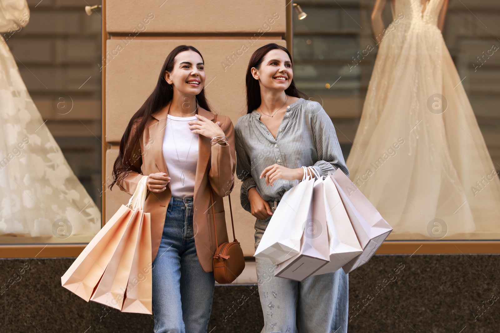 Photo of Happy women with colorful shopping bags outdoors