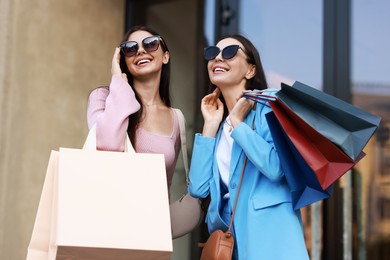 Happy women with colorful shopping bags outdoors