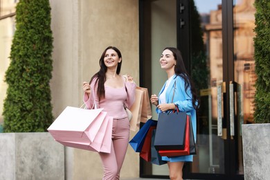 Happy women with colorful shopping bags outdoors