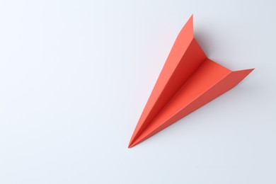 Photo of One handmade coral paper plane on white background, top view. Space for text