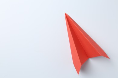 Photo of One handmade coral paper plane on white background, top view. Space for text