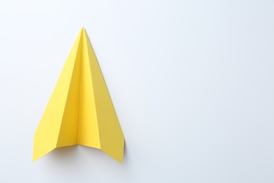 Photo of One handmade yellow paper plane on white background, top view. Space for text