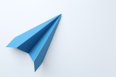 Photo of One handmade light blue paper plane on white background, top view. Space for text