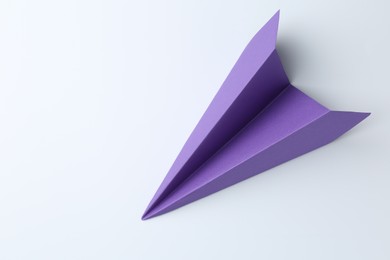 Photo of One handmade purple paper plane on white background, top view. Space for text