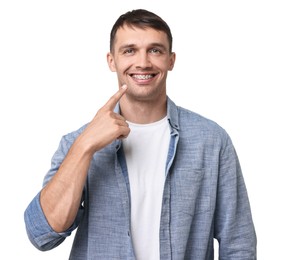 Smiling man pointing at his dental braces on white background