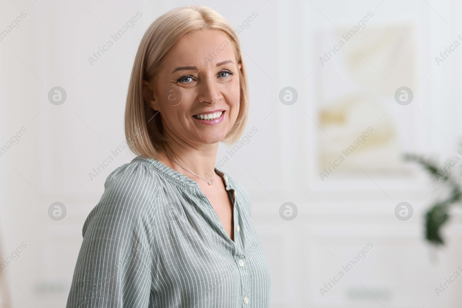 Photo of Portrait of happy middle aged woman indoors, space for text