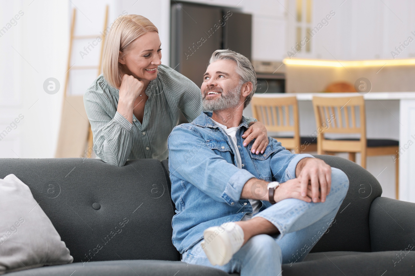 Photo of Happy middle aged couple looking at each other in kitchen