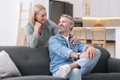 Happy middle aged couple looking at each other in kitchen