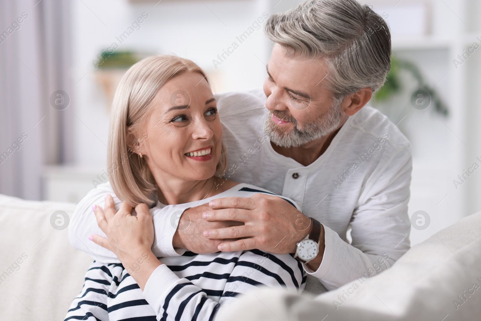 Photo of Happy middle aged couple looking at each other indoors