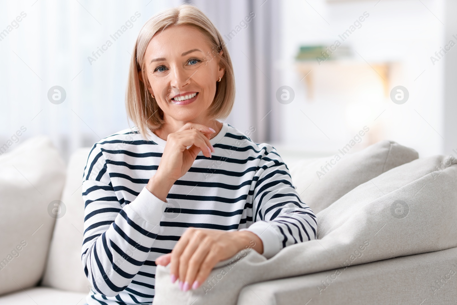 Photo of Portrait of happy middle aged woman on sofa at home