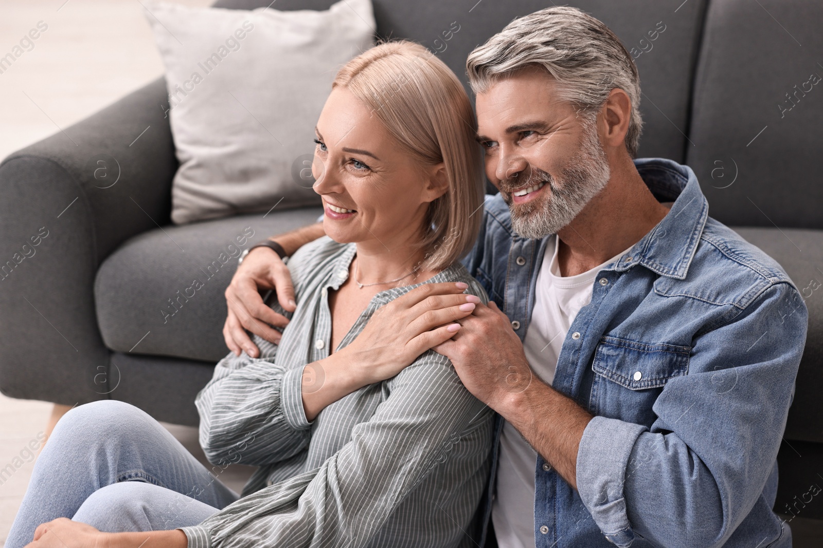 Photo of Happy middle aged couple on floor at home