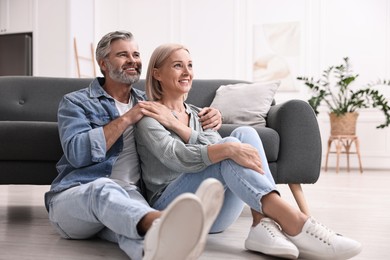 Photo of Happy middle aged couple on floor at home