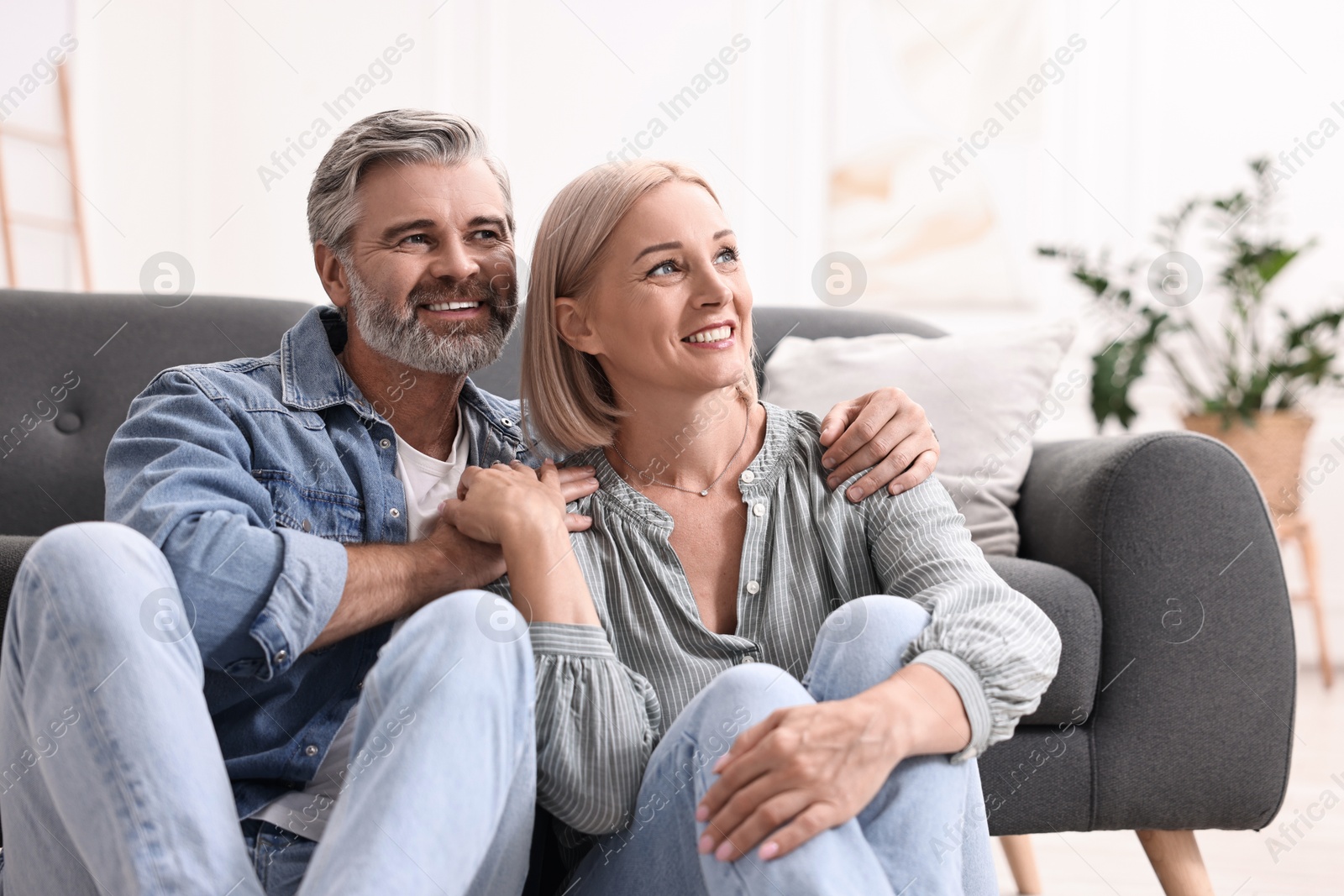 Photo of Happy middle aged couple on floor at home