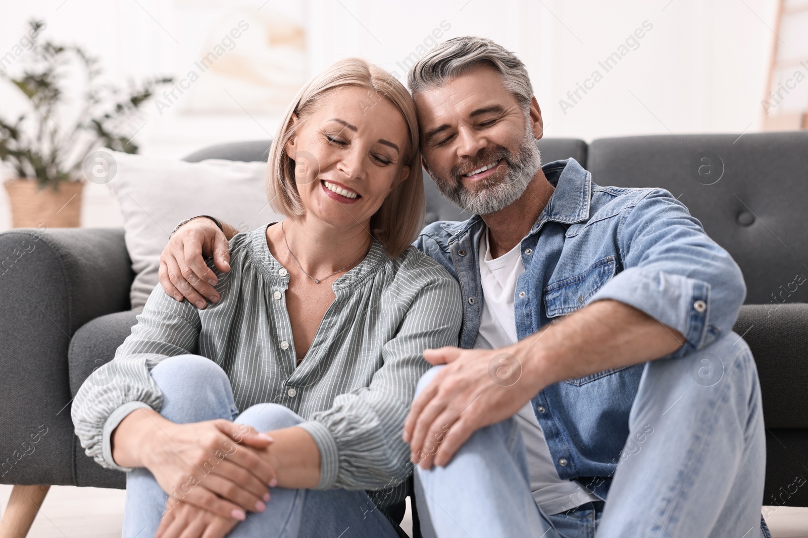 Photo of Happy middle aged couple on floor at home