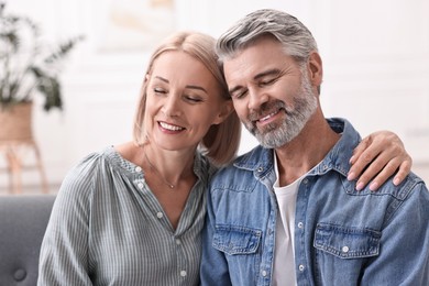 Portrait of happy middle aged couple at home