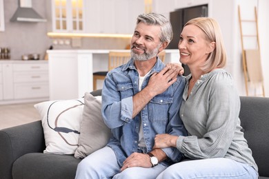 Happy middle aged couple on sofa in kitchen