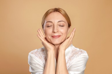 Portrait of beautiful woman with healthy skin on beige background