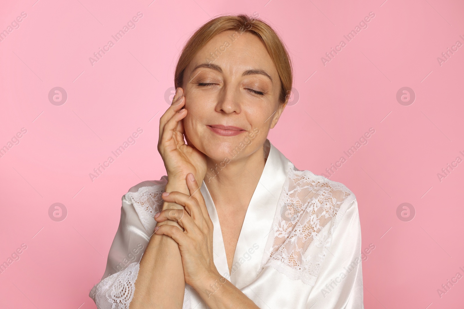 Photo of Portrait of beautiful woman with healthy skin on pink background