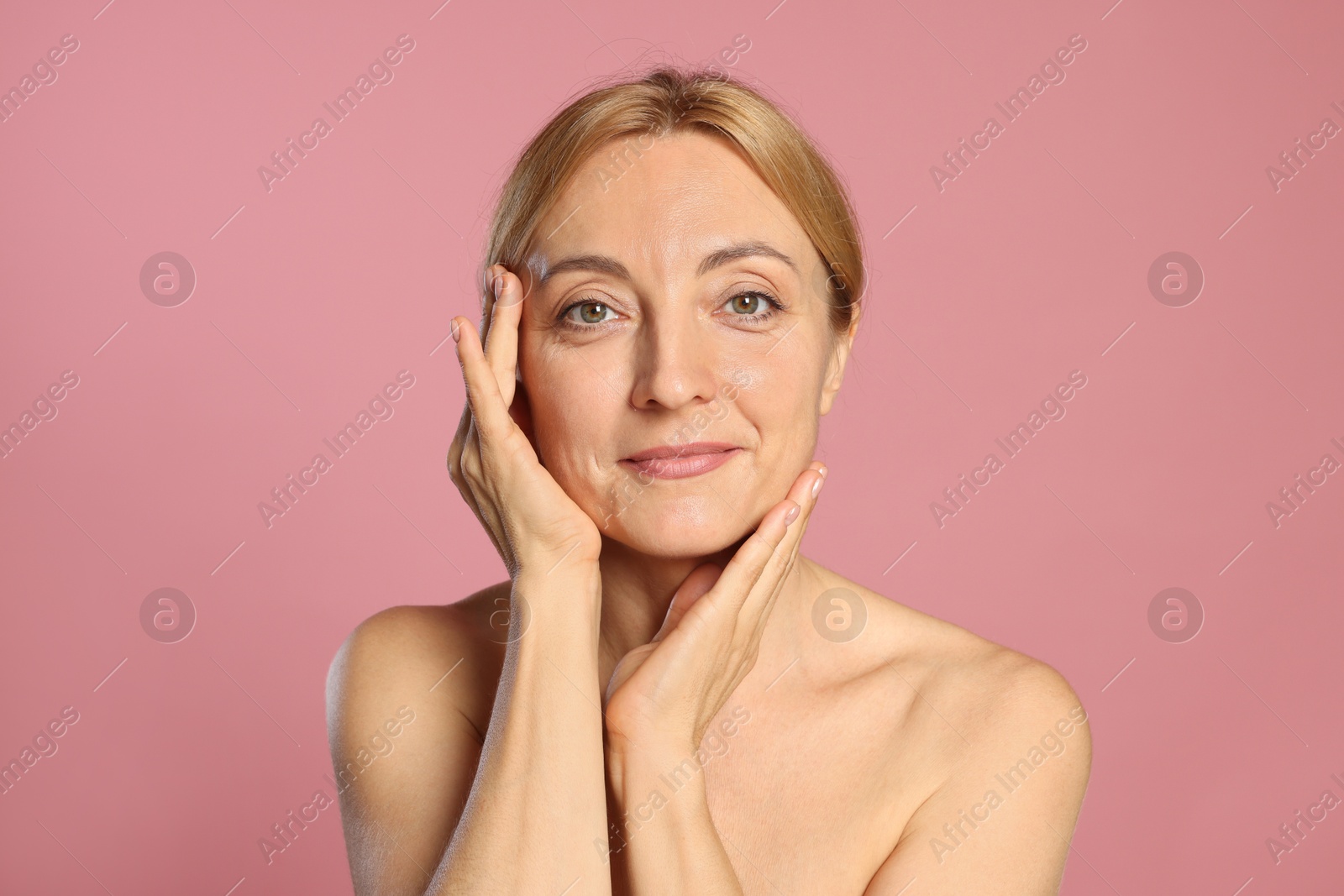 Photo of Portrait of beautiful woman with healthy skin on pink background