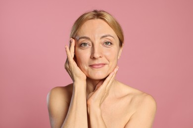 Portrait of beautiful woman with healthy skin on pink background