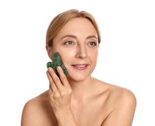 Smiling woman doing facial self massage with gua sha tool on white background