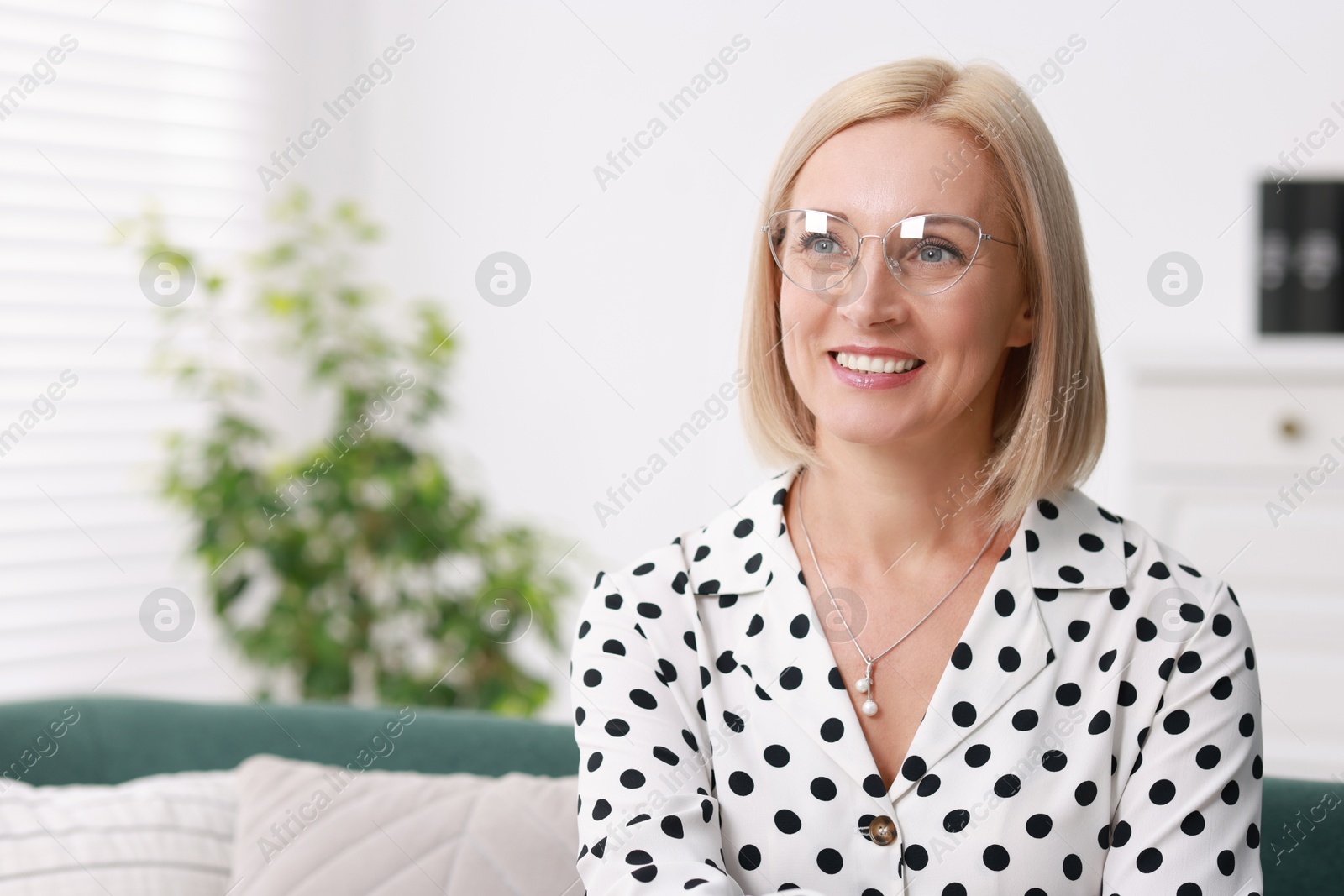 Photo of Portrait of smiling middle aged woman at home. Space for text