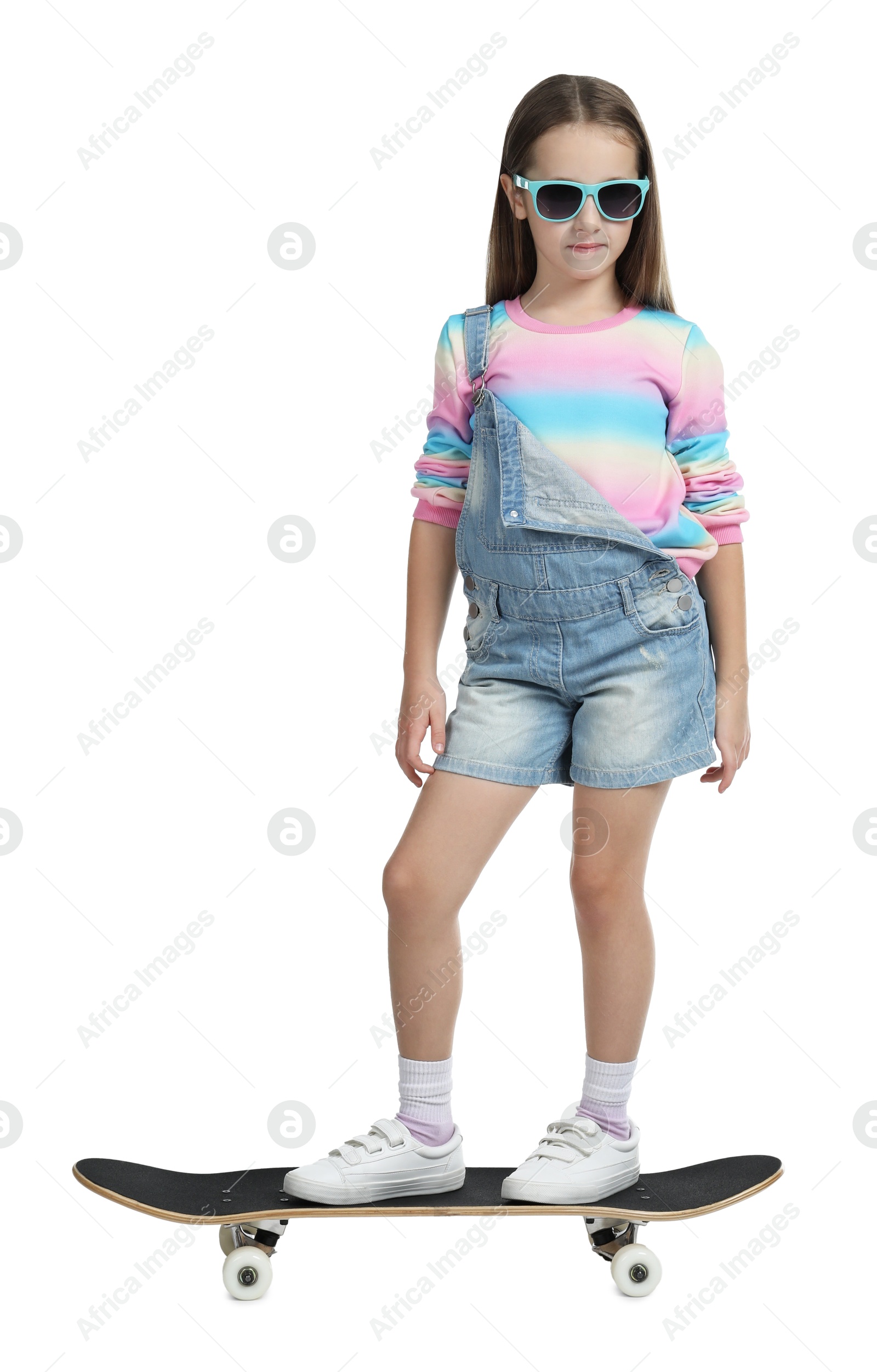 Photo of Stylish girl in glasses standing on skateboard against white background