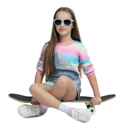 Photo of Stylish girl in glasses sitting on skateboard against white background