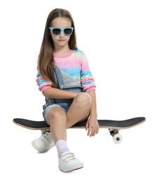 Photo of Stylish girl in glasses sitting on skateboard against white background