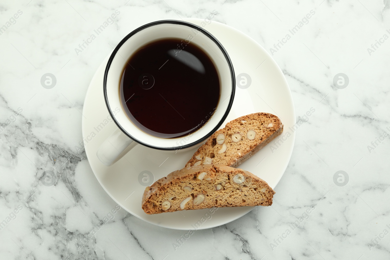 Photo of Traditional Italian almond biscuits (Cantucci) and cup of coffee on white marble table, top view