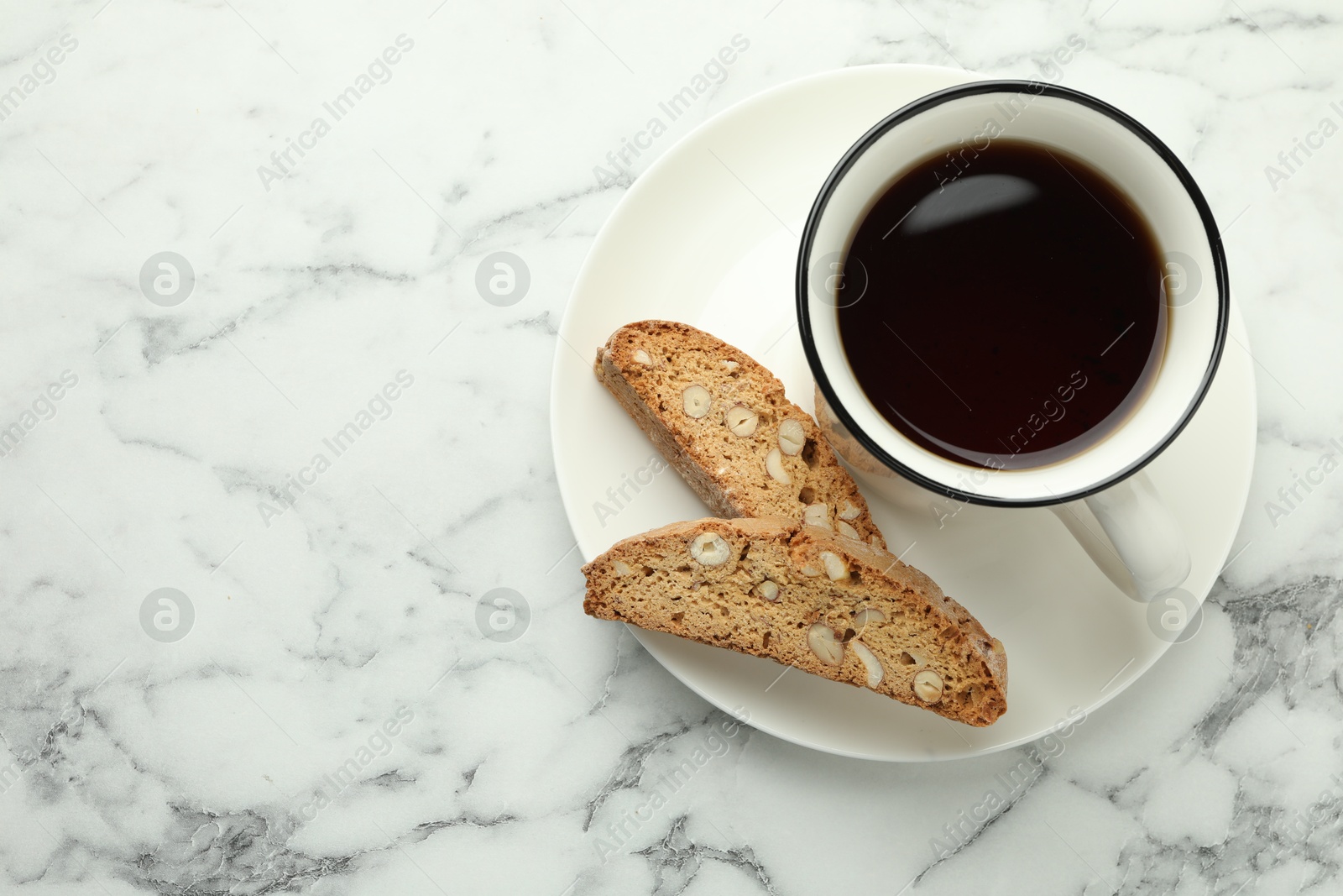 Photo of Traditional Italian almond biscuits (Cantucci) and cup of coffee on white marble table, top view. Space for text