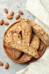 Photo of Traditional Italian almond biscuits (Cantucci) and nuts on grey textured table, flat lay