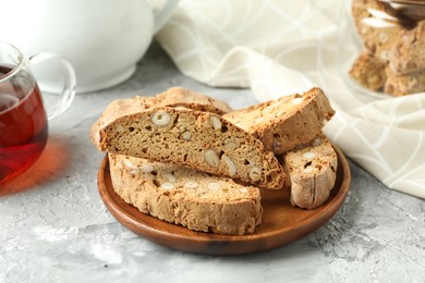 Photo of Traditional Italian almond biscuits (Cantucci) on grey textured table, closeup