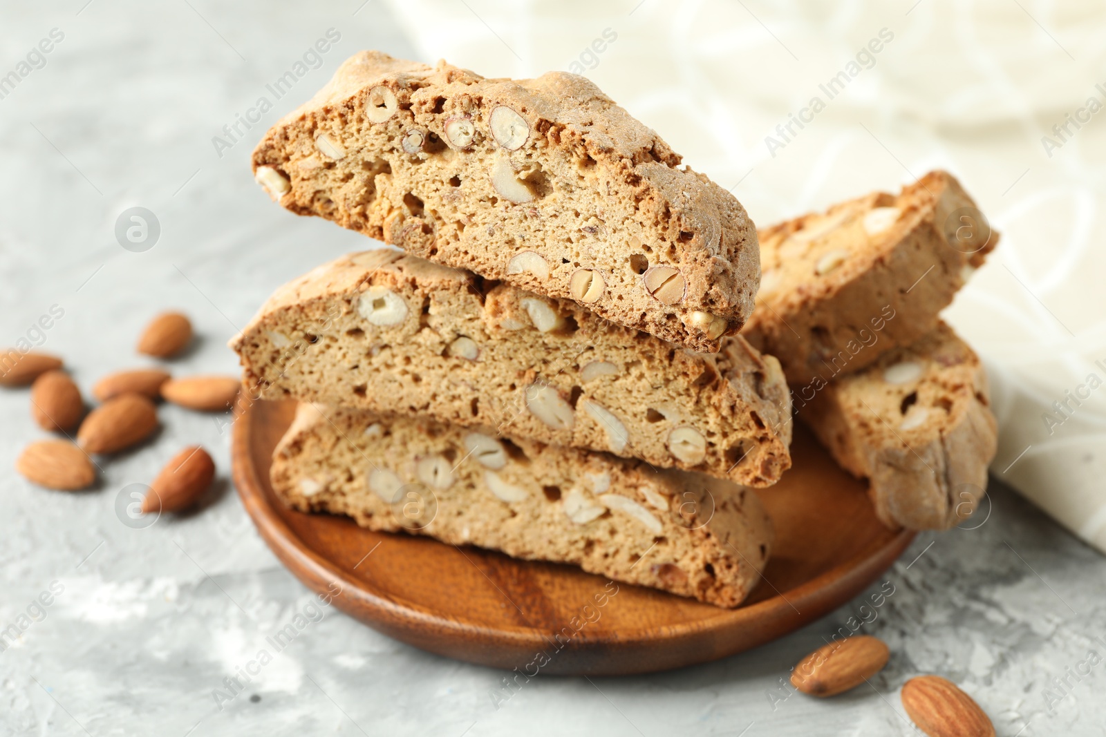 Photo of Traditional Italian almond biscuits (Cantucci) on grey textured table, closeup