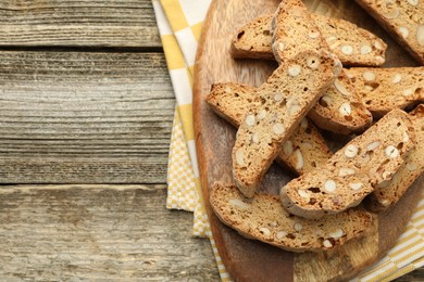 Photo of Traditional Italian almond biscuits (Cantucci) on wooden table, top view. Space for text