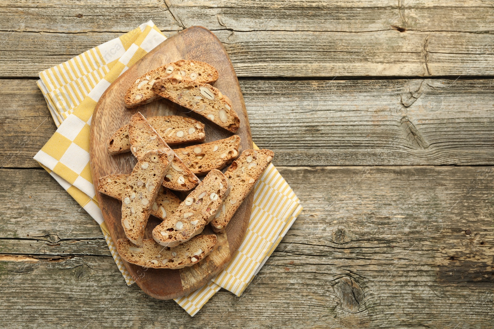 Photo of Traditional Italian almond biscuits (Cantucci) on wooden table, top view. Space for text